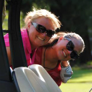 Picture of smiling golfers in golf cart on course